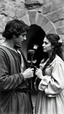 Placeholder: An old picture style of black and white mono very bad quality looks very old camera picture of Romeo is giving a rose to Juliet both dress year 1700