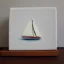 Placeholder: tiny oil painting of tiny sailboat, tiny white canvas, tiny white frame, melancholy, tender, moody, vintage, delicate arrangement, beautiful composition, etsy, aesthetic layout, plain solid white background