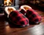 Placeholder: Red plaid slippers on black bearskin rug,log cabin walls, stone fireplace