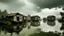 Placeholder: floating shanty houses grouped on a lake under a sky that threatens rain, also some small fishing boats working among some trees and plants that emerge from the plane of the water, cold, humid and threatening at the same time poetic environment, image taken from a low point of view