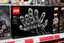Placeholder: Lego box on display at a toy store shelf, LEGO™️ box labeled "BEKSINSKI", image on box is a nihilistic six fingered hand made out of Lego blocks with nightmarish faces on the fingertips, sinister, pronounced clear LEGO block raised pip textures on all surfaces, unsettling juxtaposition of lego fun and Zdzislaw Beksinski's nightmare surreal art