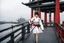 Placeholder: In a surreal twist of fate, a woman emerges on the bridge of the Potemkin, a Japanese battleship from World War II. She stands clad in a 1960s style bloody and white mini dress like an armored onna bugeisha warrior , wielding a katana with ancient grace. The fusion of eras and cultures creates a psychological thriller atmosphere, akin to a scene from the "Twilight Zone."