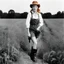 Placeholder: [photo by Helmut Newton] Grown up Pippi Longstocking: with a revealing overalls and cowboy boots in a field