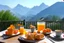 Placeholder: breakfast on a table on the terrace (orange juice, coffee in a cup, fruit, pastries), view of the mountains in the distance