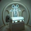 Placeholder: Background of a small circular atrium, an apparitional translucent ghost of an Iconic Disney mouse hovering over a metallic retro futuristic cryogenic frosted glass casket laying on a plinth in center of room, casket with a gold nameplate of "WALT" is plugged into a box like machine with a nitrogen tank on it which leaks frost and freezing vapors, sense of unsettling dread, grainy photography, eerie