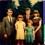 Placeholder: awkward family photo, all wearing the same type of clothes, 1960s, polaroid colors, scratches and dust on photo