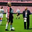 Placeholder: Hillary Clinton in a referee jersey officiating for a soccer match at Wembley Stadium