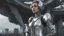 Placeholder: three-quarter view of a woman in a silver robotic catsuit standing in a futuristic derelict city with mushrooms with tentacles floating in the sky