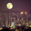 Placeholder: There is a full moon over the tall buildings in Seoul, night scene.