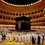 Placeholder: The scene in Mecca: People wearing white Ihram clothes, men without head coverings, women with veils, circumambulating around the Kaaba, and above them are transparent white spirits of children, men, and women with wings revolving around the Kaaba.