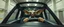 Placeholder: car driving happy 2d insect anime alien gremlin man in the style of Escher and Giger and Fallout 4, pinhole cam, airbrush 3d rendering, on tv screen:A five-second cinematic single take in a clean industrial presentation hall.