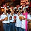 Placeholder: very Gay Giraffes sailors with white shirts and berets and tight jeans standing in a bar drinking drinks with umbrellas, pride, makeup, smoking cigaretts, smiling, sparkling eyes, very happy, after dark, pink scarf, happy hour drinks sign, necking, happy cock hour, pride, pride and pride