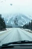 Placeholder: surreal mountain road seen through a dirty truck front window, dirty blue snow and wind, virgin mary hanging