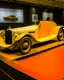 Placeholder: A light yellow racecar on a race track painted by Gustav Klimt