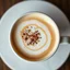 Placeholder: close up top-down view of a latte with a shape of a the milky way galaxy formed in the milky foam, cinnamon and chocolate shaving sprinkles, surreal, professional photography, looks like an advertising campaign photo, delicious