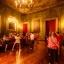 Placeholder: Party in a schloss, cheering people, Austrian aesthetic, warm colors, wooden floor, green walls, red, 8k, HD, cinematography, photorealistic, Cinematic, Color Grading, Ultra-Wide Angle, Depth of Field, hyper-detailed, beautifully color-coded, insane details, intricate details, beautifully color graded, Cinematic, Color Grading, Editorial Photography, Depth of Field, DOF, Tilt Blur, White Balance, 32k, Super-Resolution, Megapixel, ProPhoto RGB, VR, Halfrear Lighting, Backlight