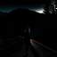 Placeholder: dark night, a woman silhouette on the side of the road,, mountains and forests next to the road, a sunrise in the distance, photo quality