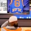 Placeholder: a man watching the New York Knicks on a very small television