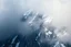 Placeholder: a massive sheer snowy mountain cliff with very sparse vegetation scaling vertically into the sky, partially obscured by dense clouds(color d0d1d5) and mist. the borders — top, bottom, left, and right — fade smoothly into thick fog, while the center reveals the steep, rocky cliff face with fine texture and detail. atmospheric lighting, cinematic composition, natural colors, high contrast between fog and stone. photography