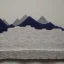 Placeholder: Model of Niesen made of wool knitting, grey, black and white, mountains in the background