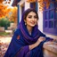 Placeholder: Hyper Realistic Photographic-Close-Face-View of Beautiful Young Happy Pashto Woman Wearing Navy-Blue-Dress-With Purple-Embroidery & Purple Shawl Happily Sitting Outside Her Blue Colored-House-with-Orange-windows at beautiful-day-time with leaves-falling from thick-trees with-sun-rays & water-fountain-at-the-back showing dramatic & cinematic ambiance.