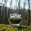 Placeholder: Create hyper-realistic photo of a glass tumbler in a wild forest. Inside, a miniature [Istanbul] with landmarks. A sleek white 3D text of [City] blends naturally into the landscape . Soft bright daylight, reflections, and subtle imperfections like fingerprints. DSLR quality, sharp focus.