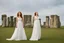 Placeholder: A tall slim red-headed woman, in a white floaty dress, standing in front of Stonehenge