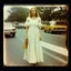 Placeholder: old Autochrome photo with black frame, Young Singer Michelle Phillips in 1900s, in the street; long white hippie dress,