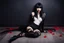 Placeholder: Full-body shot, of slender emo woman, lying on the floor, long straight dark hair with bangs, fair skin, red lips, slender, stockings, stilettos, fantasy background