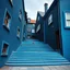 Placeholder: Fotografia di strada assurda e falsa orripilante blu weirdcore dai colori vivaci, liminalcore. Scale che scendono. Yves Tanguy. Non luogo falso, inusuale. Le case sono false e dipinte di nero chiaro con cose stilizzate e dettagli. Ci sono finestrelle false quadrate, che danno un senso distopico e molto surreale, disposte in modo casuale. L'atmosfera generale sembra noiosa e onirica, con un contrasto tra elementi reali ed elementi dipinti falsi, René Magritte, oddest things