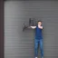 Placeholder: skinny guy lifting garage door on a rainy day