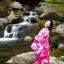 Placeholder: jolie femme asiatique en kimono près d'une cascade d'eau transparente entouré de cerisiers du japon avec aurore boréale rose