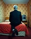 Placeholder: man with plastic bag over his head sits on the edge of a bed with his feet on the ground, facing camera, inside an old, 70s style motel room with tacky wall paper. he is wearing a black suit with a melincholy attitude. there is a box tv facing away from camera, illuminating his front. from this view, you cannot see the front of the tv. full room view, super wide shot, 24mm lens view, film syle.