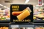 Placeholder: satirical product advertisement, Trojan brand black and gold sandwich bag box on display on a grocery store shelf, "RIBBED SANDWICH BAGS", picture on box is a long tubular hot dog bun poking out of an opaque yellow crenelated plastic bag, photorealistic, HD, natural lighting, Trojan brand logo