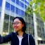 Placeholder: A short haired, bespectacled Asian female software engineer taking a selfie in front of Building 92 at Microsoft in Redmond, Washington