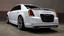 Placeholder: "A sleek white Chrysler 300 with custom LED headlights and smoked taillights, featuring a mesh grille in chrome with black accents. It has a subtle carbon fiber ducktail spoiler, sitting on 22” multi-spoke concave wheels in brushed silver. The suspension is lowered slightly for a more aggressive stance, while the body is painted a glossy black. The interior boasts custom leather upholstery with ambient lighting for a refined, luxurious look."