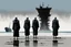 Placeholder: (((three)) long-legged lean determined black-grey monks with ((beak-shaped heads)) (wearing white khiton) standing in front of a shipwreck on a radioactive beach, front view, acrylic painting, minimal art, centered, wild sparse brushstrokes, amazing verticals, great parallels, low bleak colors of gray, blue and black, excellent negative space contrasts