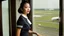 Placeholder: A very pretty Asian model in an air hostess uniform looking out of the window