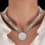 Placeholder:  necklace with a simple, elegant design featuring a single, shimmering crystal pendant