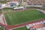 Placeholder: Cândido de Oliveira" Football Stadium, an aerial photograph taken by a drone in a futuristic landscape in an abandoned Alentejo village with white neon light, Shot on Canon EOS R5, 50mm lens, depth of field, shutter speed 1/ 1000, f/ 2. 8, white balance, 6000k. High resolution, realistic details, HDR efects, film grain, 4K. –ar 16: 10 –