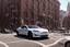 Placeholder: A Tesla 'Model Y' is parked, near the Flatiron Building in Manhattan. (CINEMATIC, WIDE ANGLE LENS, PHOTO REAL)