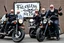 Placeholder: a very hard and tuff motorcycle bald gang, not old, posing with their Harley Davidsson bikes, some of them holding guns and shotguns, a logo sign with Falköpings HD Club, "Fearless sinners" Skulls and bones, skeletons