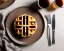 Placeholder: Round waffles with maple syrup plate, plaid napkin fork