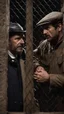 Placeholder: close-up photo, two Italians nightwatchmen, 45 years old, stocky, unshaved, at night, talking each other inside a guardhouse top-lit along the fence of a building, photorealistic, photographic, 32k