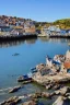 Placeholder: gothic, medieval, fishing town, rocks, long piers, fishing boats, shops, blue sky