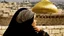 Placeholder: A woman wearing a keffiyeh holds the Dome of the Rock