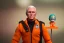 Placeholder: Mike pence G.i. joe toy doll space force uniform inside a blister package hanging on A rack in toystore, fluorescent orange, wide angle shot whole body, black moonboots, Green, holding space helmet under arm, whole body shot