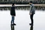 Placeholder: An image of two people exchanging criticism in a constructive and respectful manner, standing on the ground with a lake behind them