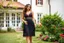 Placeholder: very beautiful lady with beautiful midi dark black-red lace skirt and lace top with curvy hair sports shoes standing in a nice villa yard with trees flowers ,16 by 9