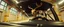 Placeholder: car driving happy 2d insect anime fluffy slimy alien okapi deer gremlin man in the style of Escher and Giger and Fallout 4, pinhole cam, airbrush 3d rendering, on tv screen:A five-second cinematic single take in a clean industrial presentation hall.